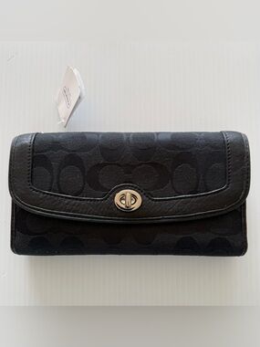Coach Signature canvas trifold wallet featuring a turnlock closure leather trim